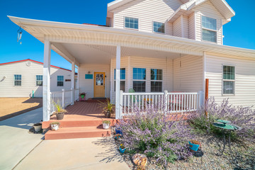 Large covered white porch on a white timber house