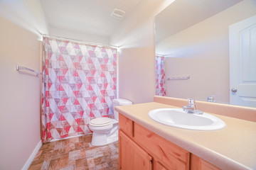 Neat clean bathroom with closed shower curtain
