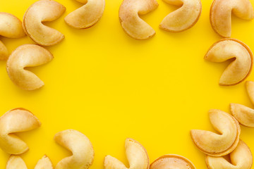 Fortune cookie frame on yellow background top-down copy space