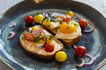 Morning breakfast toast with egg, bread, cherry tomatoes, onion, and cheese.