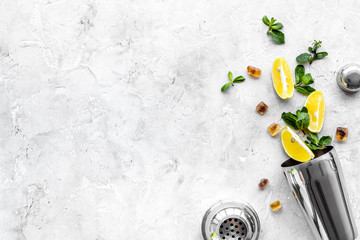 Bar background. Tools and ingredients for making cocktails. Shaker, lime, ice on grey background...
