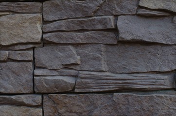 Fragment of an old wall made of dark gray bricks. Close up. Background. Texture.	