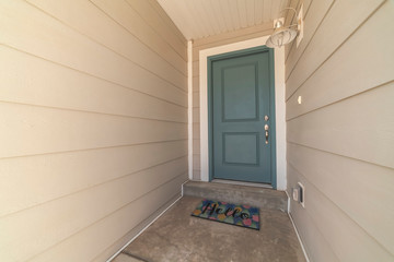 Blue wooden front door with Hello welcome mat