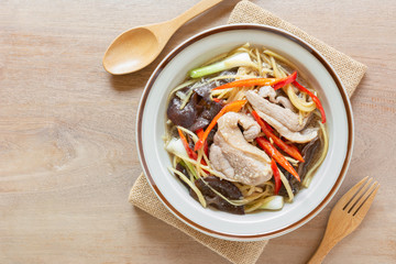 top view of stir fried duck meat with ginger and vegetable in a ceramic dish on wooden table. homemade style hot and spicy food menu.