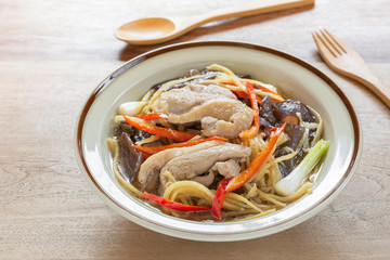 close up of stir fried duck meat with ginger and vegetable in a ceramic dish on wooden table. homemade style hot and spicy food menu.