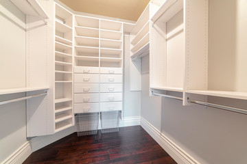 Fully fitted empty white walk-in wardrobe bright interior