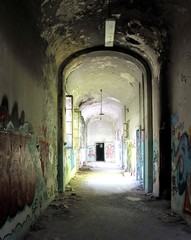 2019.06.16 - Limbiate, Milan, Italy, photographic reportage madhouse in Mombello, abandoned psychiatric hospital long macabre corridor with spray paint on the walls