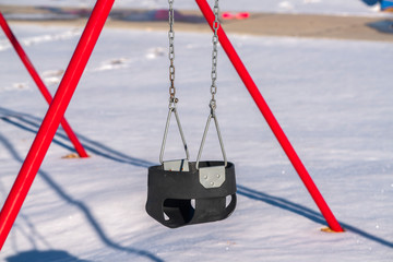 Close up on a kids swing in winter snow