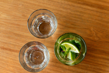 A glass of mineral water with lime, mint in the hands of a girl.  The concept of healthy drinks, detox. Top view.