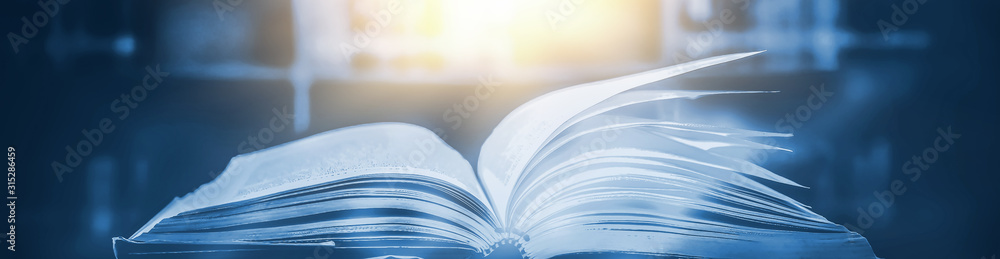 Poster imagine a picture book of an ancient book opened on a wooden table with a sparkling golden backgroun