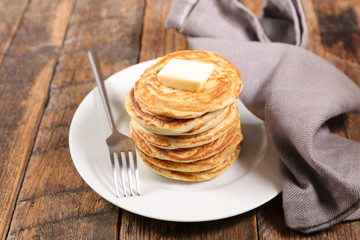 pile of pancake with butter on wood background