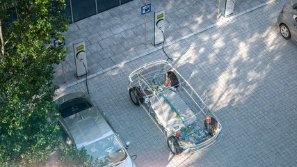 generic electric car with battery visible x-ray charging at public charger in city parking lot 3d...