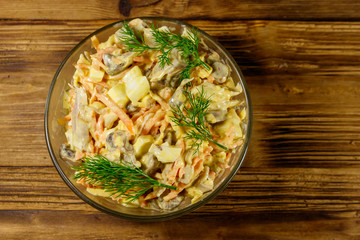 Tasty salad with chicken breast, roasted mushrooms, carrots, grated cheese, eggs and mayonnaise on wooden table. Top view