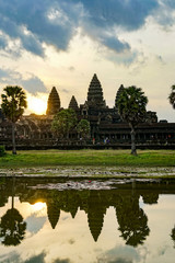 Fototapeta na wymiar Angkor Wat, reflection of an ancient temple in the lake, dawn, morning sun, vertical photo