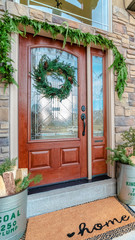 Fototapeta na wymiar Vertical Decorated front door with wreath and greenery
