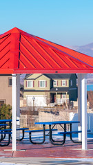 Fototapeta premium Vertical Covered picnic benches and tables under red roof