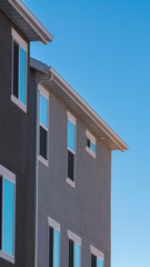 Vertical frame Facade of grey house against blue sky