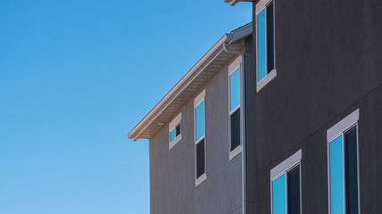 Fototapeta na wymiar Panorama Facade of grey house against blue sky
