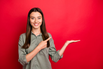Portrait of her she nice-looking attractive confident cheerful cheery straight-haired girl holding invisible object on palm ad isolated over bright vivid shine vibrant red color background