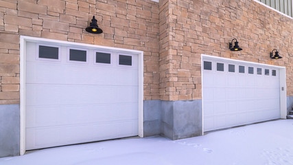 Panorama Snow covered forecourt with double garage doors