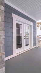 Vertical frame Glass front door to a house with covered porch