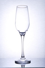 isolated emty glass goblet, on mirror surface, backlight, portrait orientation