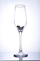 isolated glass goblet with two rings in it, light from back