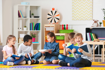 Cute little children reading books indoors