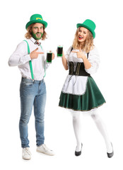 Young couple with beer on white background. St. Patrick's Day celebration