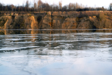 Thin ice on the water of a sand quarry. Leningrad region.