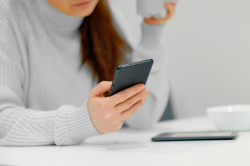 Close-up view of the female arm holding the smartphone. Concept of the smartphone using