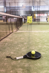 paddle tennis racket and balls in court