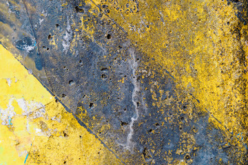 Dirty warning sign with black stripes on yellow background.