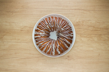 Homemade Easter cake glazed with dark and white chocolate on white plate on wooden table