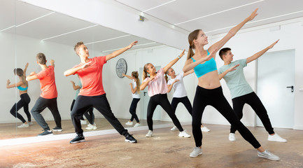 Fototapeta na wymiar Teenage dancers practicing active vigorous dance in modern studio