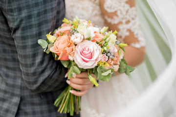 bride and groom holding beautiful wedding bouquet of flowers