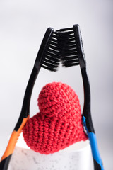 Creative image of two toothbrushes and heart figure between. St Valentines day concept