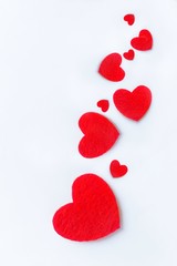 Red felt hearts on a white background. Valentine's day symbol, holiday concept. Top view with copy space for text.