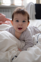 Little cute infant baby portrait in gender neutral clothes smiling