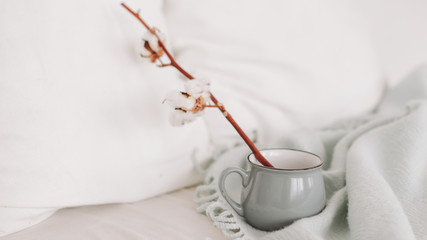 Coffee cup and cotton twig. Breakfast in bed. Cozy home. flat lay, still life.