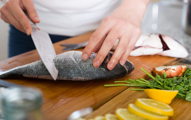 Hands cooking dorado fish