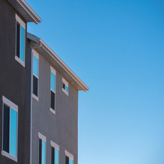 Square Facade of grey house against blue sky