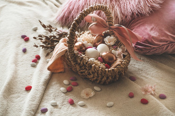 Happy Easter. Easter eggs on  in a wicker basket with multi-colored small eggs. 