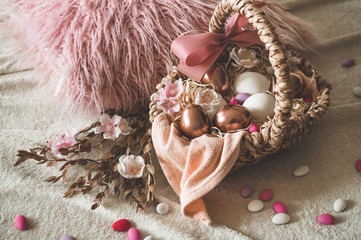 Happy Easter. Easter eggs on  in a wicker basket with multi-colored small eggs. 