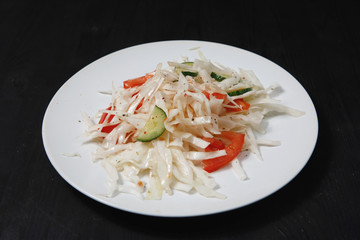 Plate with salad on the table.