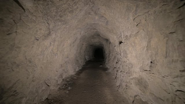Speleology artificial cave dark tunnel excavation underground. Old adit for the extraction of metal and rocks