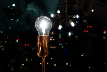 Sparkling Light bulb with night time modern urban background, symbolizing bright ideas in modern urban pulse of life - 315309496