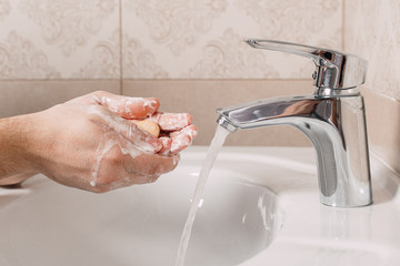 Wash hands under the tap with soap. Hygiene concept in detail. Beautiful stream of hands and water...