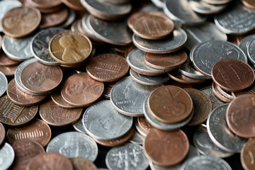 American cents coins are scattered on a black wooden surface. Money background