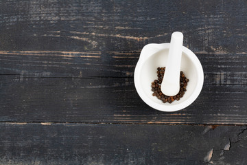 White stupa for grinding pepper on a wooden table